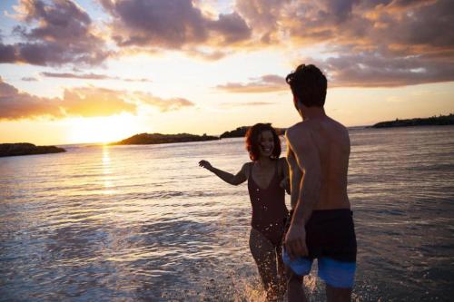 a man and a woman standing in the water at Aulani, Disney Vacation Club Villas in Kapolei