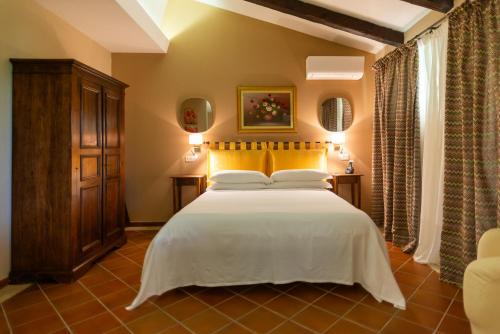 a bedroom with a large white bed with yellow pillows at Ghiaccio Bosco in Capalbio