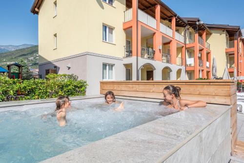 a group of three children swimming in a hot tub at Residence Maroadi in Nago-Torbole
