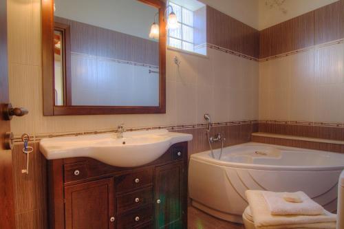 y baño con lavabo, bañera y espejo. en Askoutsi Manor, a Natural Tranquil Retreat, By ThinkVilla, en Áyios Ioánnis