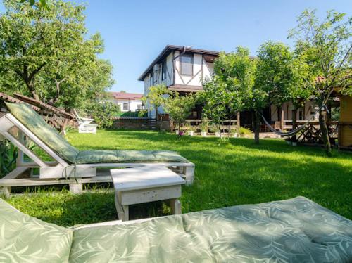 a yard with two mattresses in the grass with a house at Къща "Конакъ" in Kyustendil