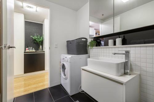 Un baño con lavadora y lavabo. en VAQUAY Verge In Brunswick East, en Melbourne