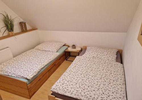 Habitación pequeña con 2 camas individuales y mesa. en Ferienhaus Polly, en Rabenau