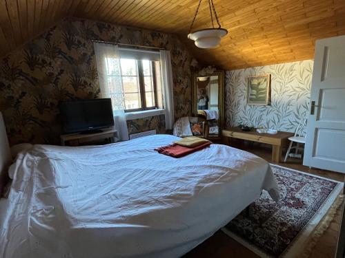 a bedroom with a large bed and a window at Viehättävä talo Mäntässä. in Mänttä