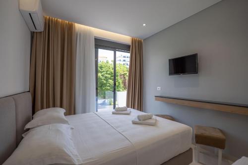 a hotel room with a bed and a window at Hotel Emblem in Sarandë