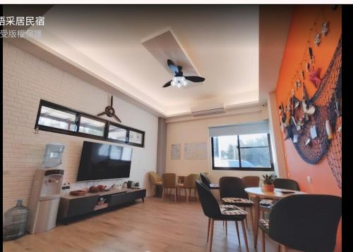 een woonkamer met een tv en een tafel en stoelen bij 星語采居民宿 in Magong