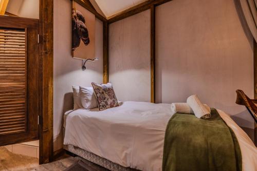 a bedroom with a bed in a room with a window at Desert Hills Glamping Camp in Sesriem