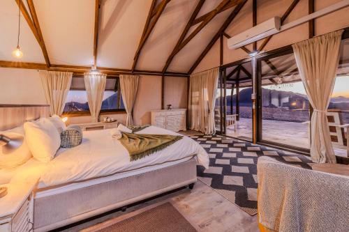 a bedroom with a bed in a room with windows at Desert Hills Glamping Camp in Sesriem