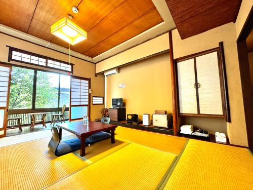 日本旅館　松亀荘 في بيبو: غرفة معيشة مع طاولة وسجادة صفراء