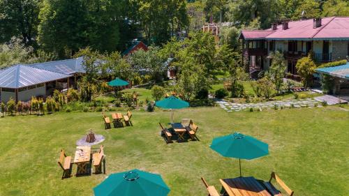 an aerial view of a yard with tables and umbrellas at Bedzzz Xclusiv Baikunth, Manali By Leisure Hotels - 650 meters from Hidimba Devi Temple in Manāli