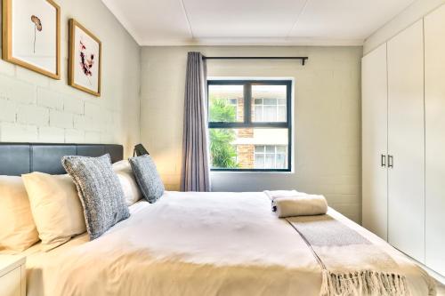 um quarto com uma cama grande e uma janela em WINK Aparthotel Eaton Square na Cidade do Cabo