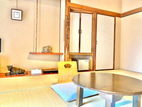 a living room with a table and a chair at 日本旅館　松亀荘 in Beppu