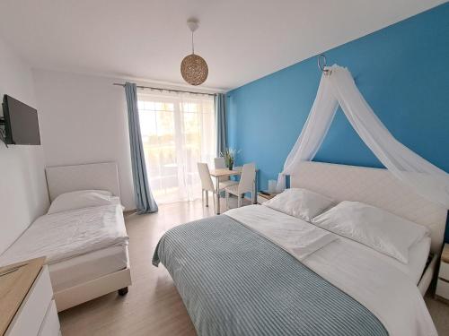 een slaapkamer met een wit bed en een blauwe muur bij Willa Baltycka Bryza in Władysławowo