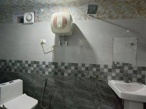 a bathroom with a toilet and a sink at Hotel Fateh Heights in Pāndukeshwar