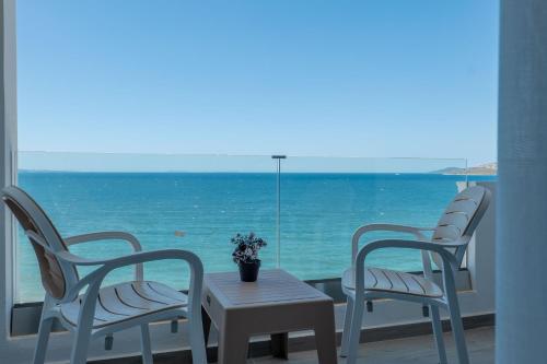 two chairs and a table with a view of the ocean at Hotel Emblem in Sarandë