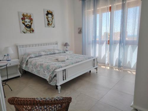 Habitación blanca con cama y ventana en Villetta Scruscio ri Mare en Favignana
