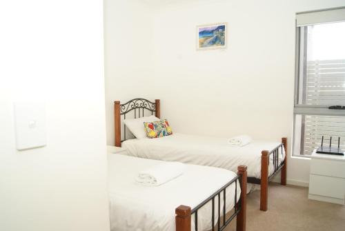 two twin beds in a room with a window at Mill View Link in Albany