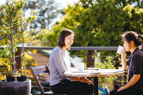 twee vrouwen aan een tafel koffie drinken bij Quality Apartments Banksia Albany in Albany