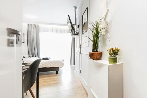 a living room with a desk with a chair and plants at Stylowe Apartamenty w Centrum in Wrocław