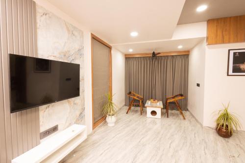 a living room with a flat screen tv on a wall at Daksh Eden Greenz -A Luxury Resort in Sasan Gir in Sasan Gir