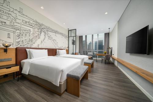 a hotel room with two beds and a flat screen tv at UrCove by Hyatt Guangzhou Tower Pazhou Exhibition Center in Guangzhou