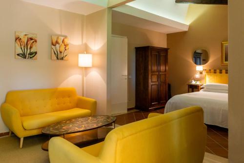 a hotel room with a bed and two chairs and a table at Ghiaccio Bosco in Capalbio