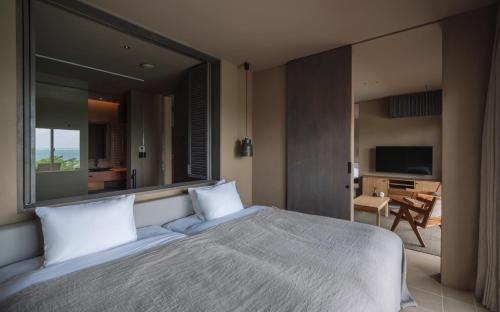a bedroom with a large bed with a large window at アヤンナ宮古島 in Miyako Island