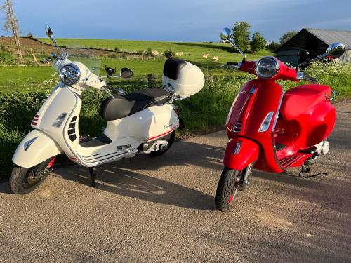 a red and white scooter parked on a road at La Remise - Les Chambres in Neufchâteau