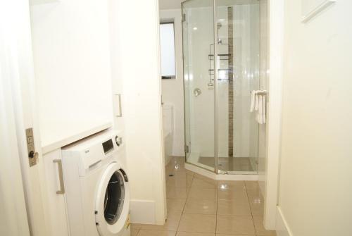 a bathroom with a washing machine and a shower at Mill View Link in Albany