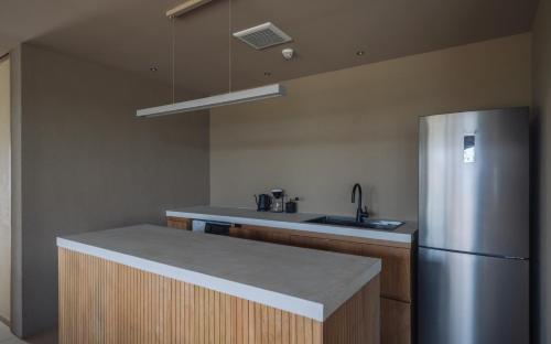 a kitchen with a stainless steel refrigerator and a sink at アヤンナ宮古島 in Miyako Island