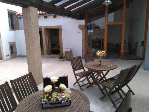 Miñortos的住宿－Casa do Fieiro，庭院配有椅子和鲜花桌子。
