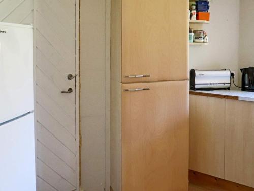 a kitchen with a white refrigerator and a counter at 6 person holiday home in HISHULT in Knäred