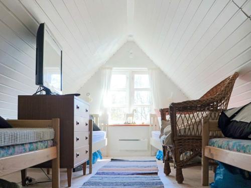 a attic room with a dresser and a window at 6 person holiday home in HISHULT in Knäred