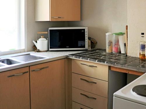 a kitchen counter with a microwave and a sink at 6 person holiday home in HISHULT in Knäred
