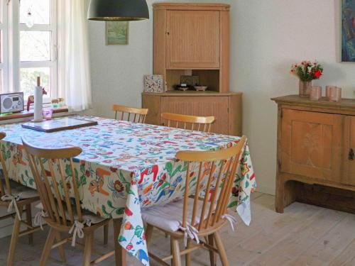 a kitchen with a table with a flowered table cloth at 6 person holiday home in HISHULT in Knäred
