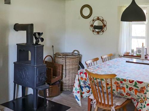 a dining room with a stove and a table at 6 person holiday home in HISHULT in Knäred