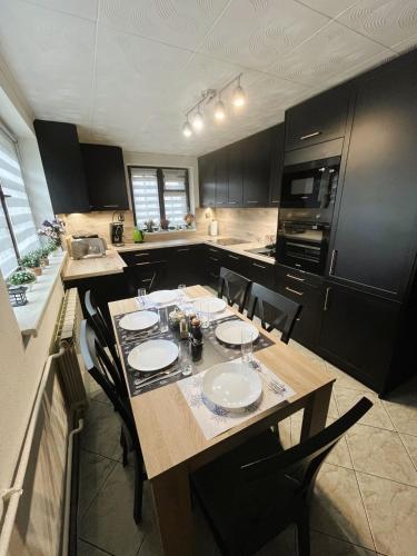 a kitchen with a wooden table with chairs and a kitchen with black cabinets at Czarne jagody in Kościelisko