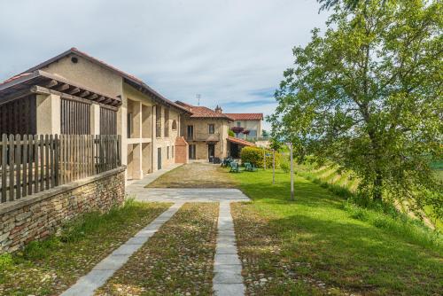 a walkway in front of a building with a tree at Serra Alta Langa Holiday Home in Trezzo Tinella