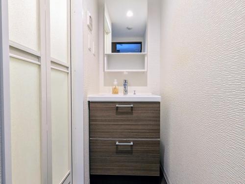 a bathroom with a sink and a mirror at Home cruise Awaza in Osaka
