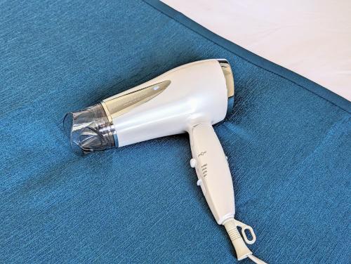 a white hair dryer sitting on a blue table at Home cruise Awaza in Osaka