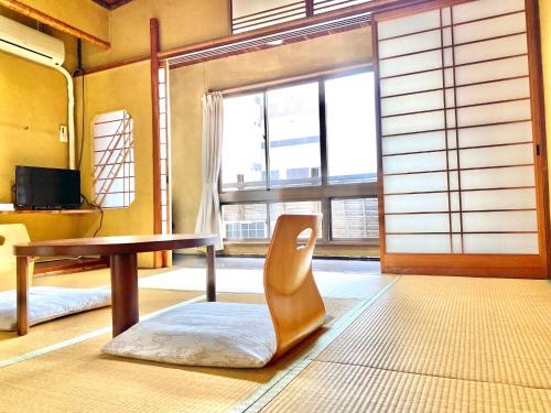 a room with a table and a chair in front of a window at 日本旅館　松亀荘 in Beppu