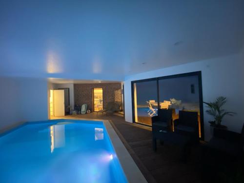 a large swimming pool in a living room at A l oree du bois piscine intérieure privée sans vis à vis in Auvilliers