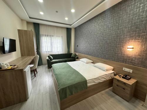 1 dormitorio con cama, escritorio y sofá en Lidzo Villa Butik Otel en Trebisonda