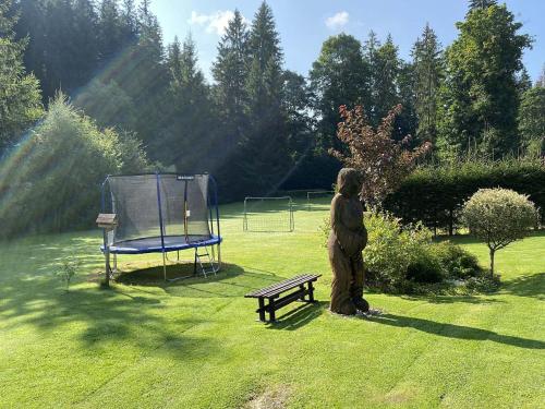a person standing in the grass next to a bench at Chata Březiny - Terezka in Březiny