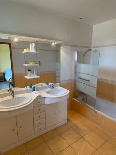 une salle de bain avec deux lavabos et une douche dans l'établissement Côté sud - spacieuse et lumineuse villa, à Les Matelles