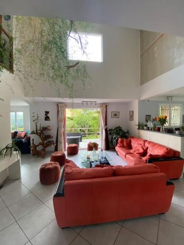 - un salon avec deux canapés rouges et une fenêtre dans l'établissement Côté sud - spacieuse et lumineuse villa, à Les Matelles