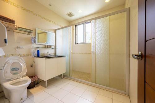 a bathroom with a toilet and a glass shower at 溪頭老爺山莊Xitou Royal Villa in Lugu