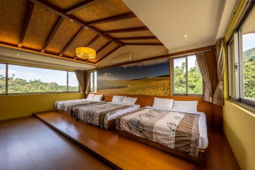 2 Betten in einem Zimmer mit großen Fenstern in der Unterkunft 溪頭老爺山莊Xitou Royal Villa in Lugu