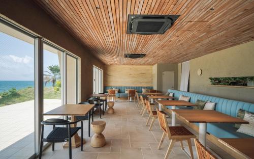 a restaurant with tables and chairs and the ocean at アヤンナ宮古島 in Miyako Island