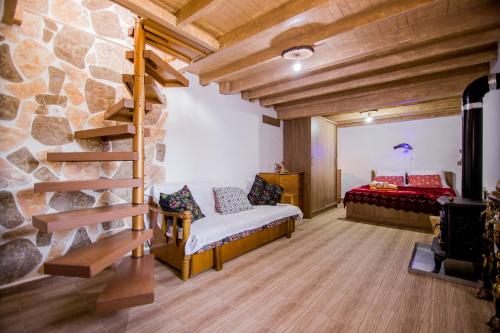 a bedroom with a bed and a stone wall at Farma House Vasilo - Escape Cottage Retreat in Evkarpía